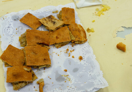 Food tray offering the remains of an empanada cut into small pieces