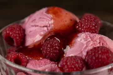 red raspberry ice cream in a glass bowl with raspberry jam