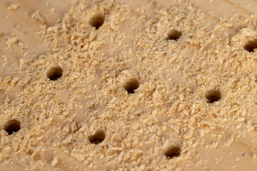 pine board that is drilled with steel drills