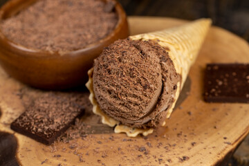 chocolate ice cream in a cone on a board