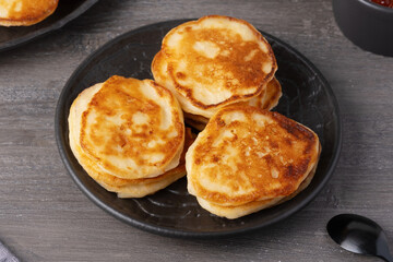 Delicious stack of golden pancakes served with caviar on a rustic table