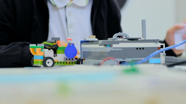 
School children teenagers in robotics school makes robot managed from the constructor, robot programming. Creative kids working on the tech project at school.