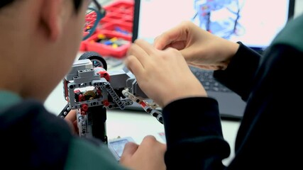 Elementary School Robotics Classroom: Diverse Group of Brilliant Children with Enthusiastic Teacher. Creative kids working on the tech project at school.
