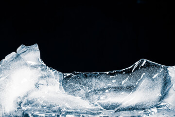 Pure translucent textured crushed ice piece on a black background.