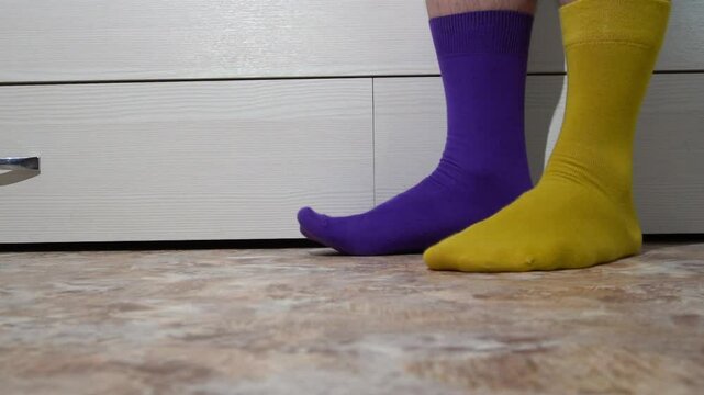 Two different mismatched socks on the feet. Day of colorful socks or Day of unpaired socks.