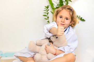 Fototapeta premium A child treats a teddy bear like a doctor. Selective focus.