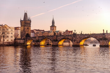 Sunset colors in Prague Historical Gothic Medieval castle, St. Vitus Cathedral, Charles Bridge and river Vltava boat cruise, astronomical clock, Unesco city tourism, golden hour and water reflection