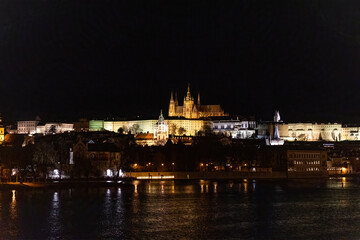 Sunset colors in Prague Historical Gothic Medieval castle, St. Vitus Cathedral, Charles Bridge and river Vltava boat cruise, astronomical clock, Unesco city tourism, night view and water reflection
