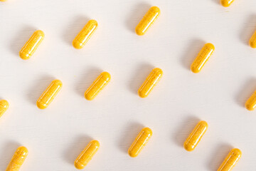 Orange medicine capsules on white background. Pattern