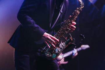 Concert view of saxophonist musician, saxophone sax player with vocalist and musical band during...