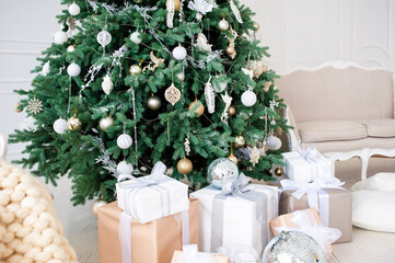 Elegant Christmas interior with a decorated tree in gold and white, wrapped gifts, a vintage beige...