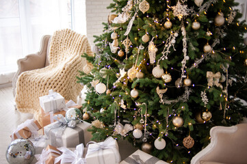 Elegant Christmas interior with a decorated tree in gold and white, wrapped gifts, a vintage beige...