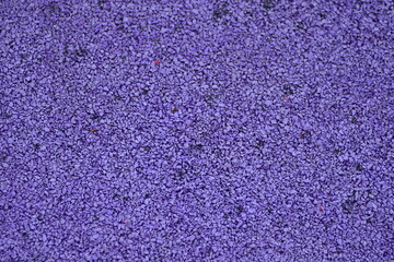 purple sports field rubber coating close up. Playground paving background texture.