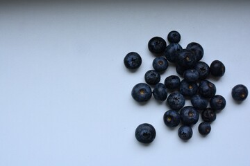 Fresh bilberries spread on white table close up top view