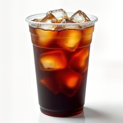 Transparent plastic cup filled with iced coffee. Lots of ice cubes are visible in the dark brown beverage. The drink appears cold and refreshing. Isolated white background.