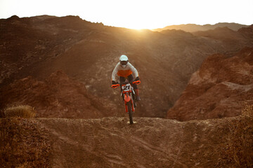 Motocross racer rides through the desert.