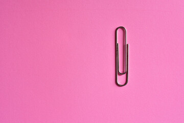 stainless steel paper clip isolated pink background