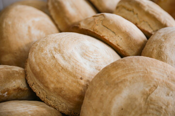 A lot of bread on a tray in a bakery. Real production.