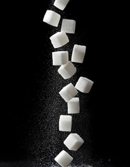White sugar cubes falling and floating freely on black background