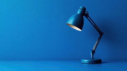Blue desk lamp illuminates blue background, workspace