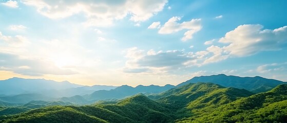 Fototapeta premium Scenic mountain range sunset view, lush green hills, clear sky. Perfect for travel, nature, or landscape designs