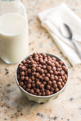 Breakfast cereal chocolate balls in bowl on kitchen table.