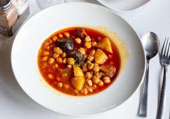 Traditional spanish food garbanzos del pastor, shepherd's chickpeas soup on a white plate