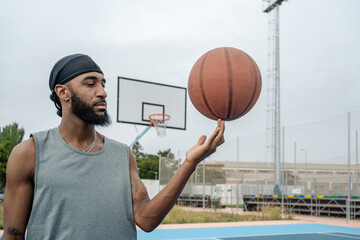 Basketball player spinning ball on finger at court