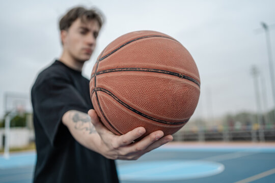 Basketball player holding ball on outdoor court