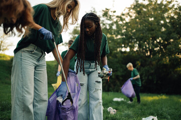 Group of volunteers picking up trash in park