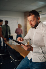 Focused businessman using digital tablet during office meeting