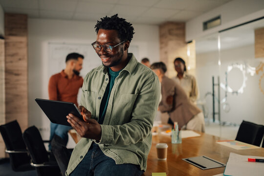 Smiling businessman using digital tablet during a meeting in the office - Powered by Adobe