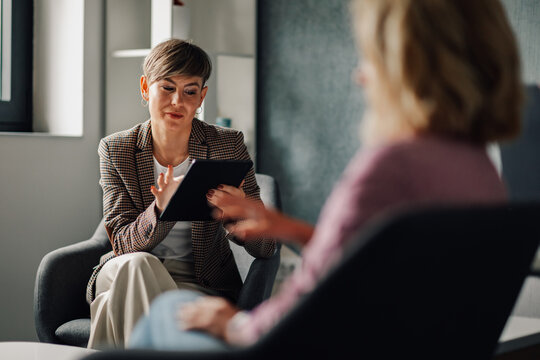 Financial advisor showing information on tablet to client