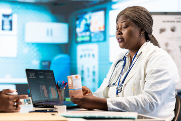 Physician recommending a sunscreen lotion with spf 50 for extra protection during summer, offering a great skincare product to black girl at dermatology checkup. UV shield moisturizer.