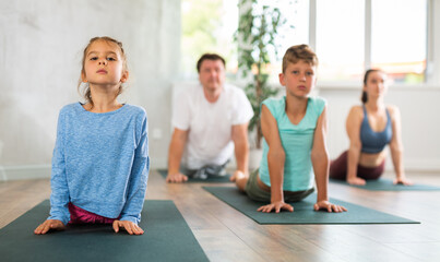 Fototapeta premium Preteen children practice yoga and Pilates with their parents