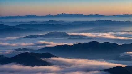 Obraz premium Expansive mountain view at dawn with fog covering the valleys