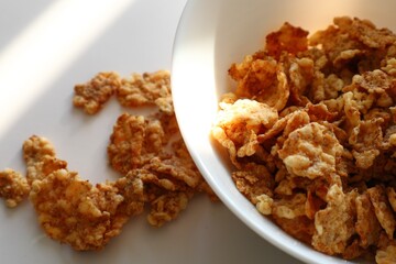 Corn flakes in a plate on a white background, close up