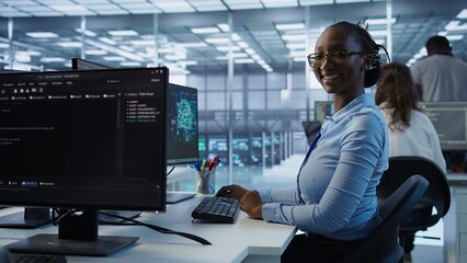 Portrait of happy computer scientist programming in AI data center used for machine learning...