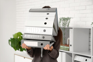 Young woman with stack of folders in office. Closeup