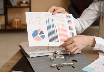 Female office worker folding documents. Closeup