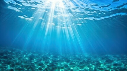 Sunlight sparkles on blue ocean waves, revealing clear waters beneath in a perfect summer scene.