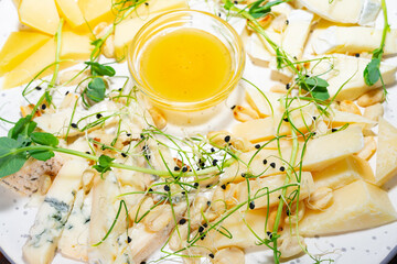 Assorted cheese platter with honey and herbs for a delightful tasting experience Savory vegetable pie served with fresh garnishes on a white plate