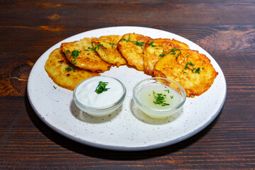 Delicious potato pancakes served with creamy dips at cozy restaurant Savory vegetable pie served with fresh garnishes on a white plate