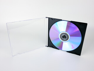 A DVD disc in an open plastic box on a white background. A digital storage medium.