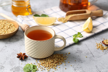 Cup of hot buckwheat tea with mint leaves and star anise on grey grunge background