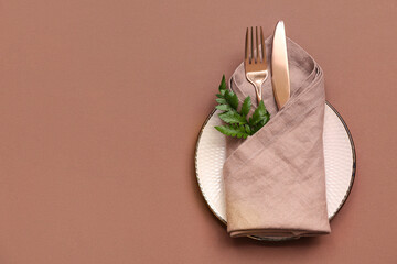 Beautiful table setting with fresh green leaf on brown background