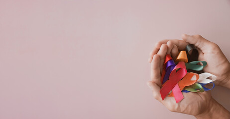 Hands holding color ribbons, world cancer day, World Autism Awareness Day concept
