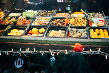 Colorful food display at a festive market during winter evening 