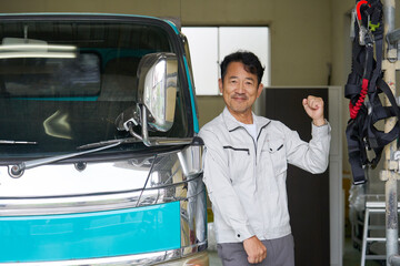 トラックのガッツポーズする男性作業員