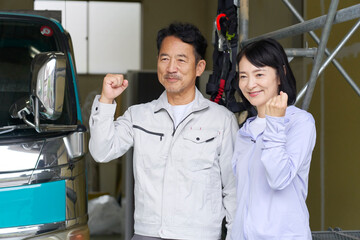 ガッツポーズする作業員の夫婦